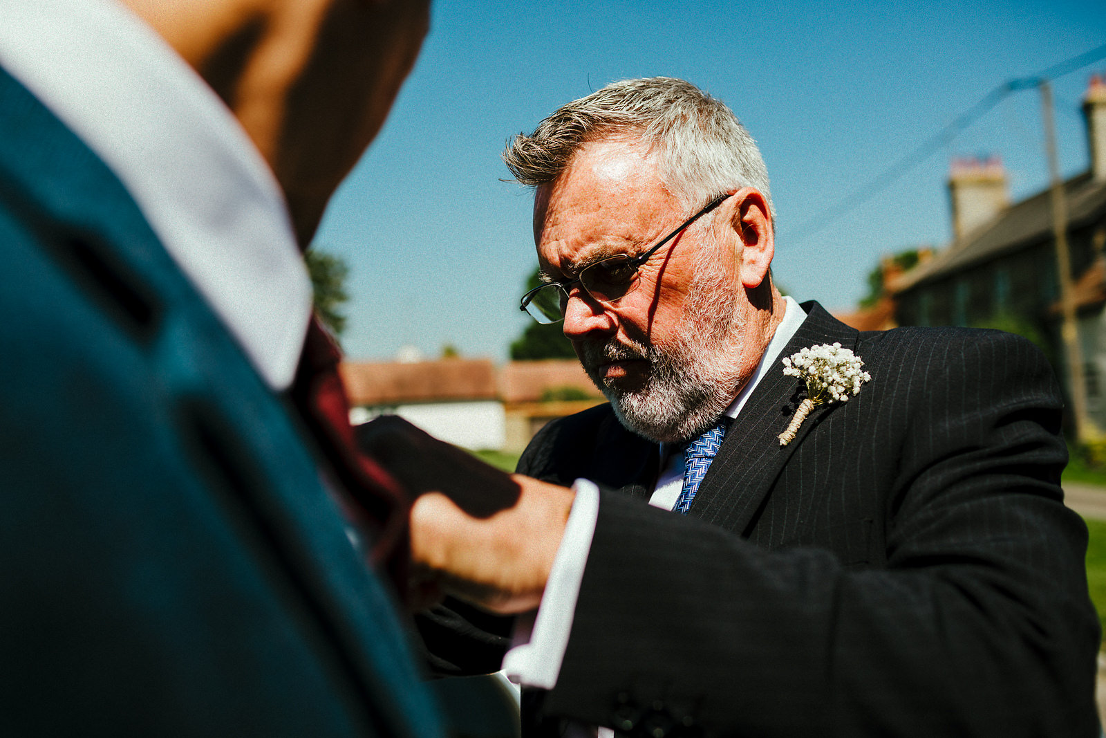 Father of the groom helping with buttonhole